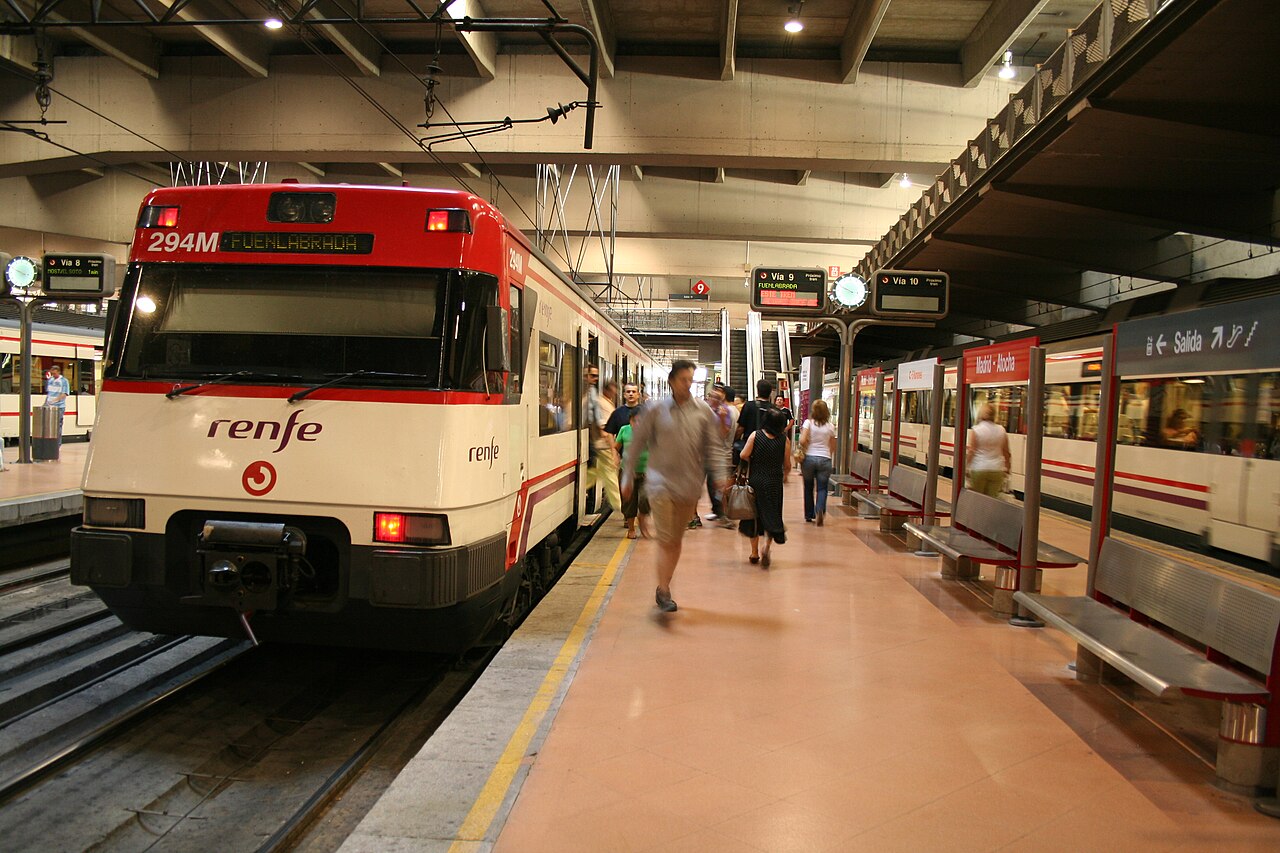 Tren de Cercanías de Renfe detenido en un andén de la estación de Madrid-Atocha con viajeros caminando